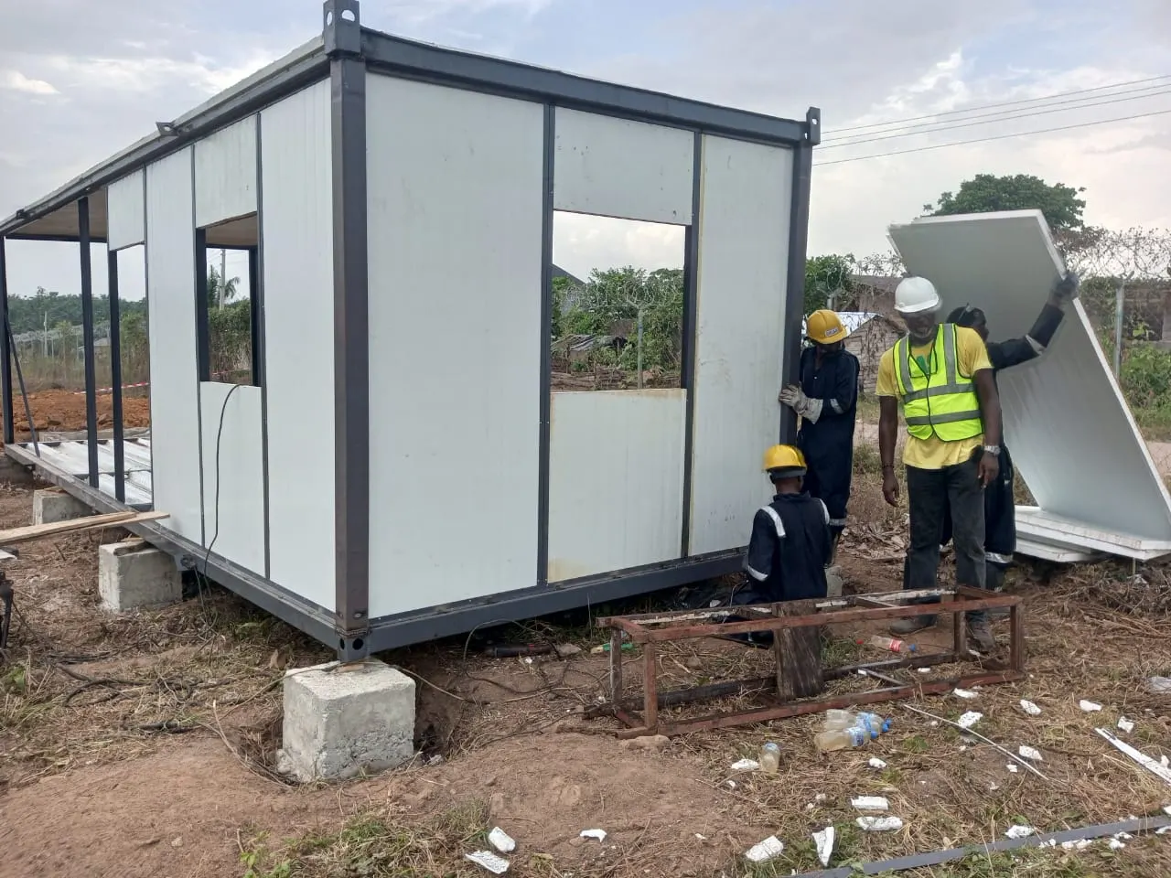Installation crew in safety gear assembling a modular cabin on site