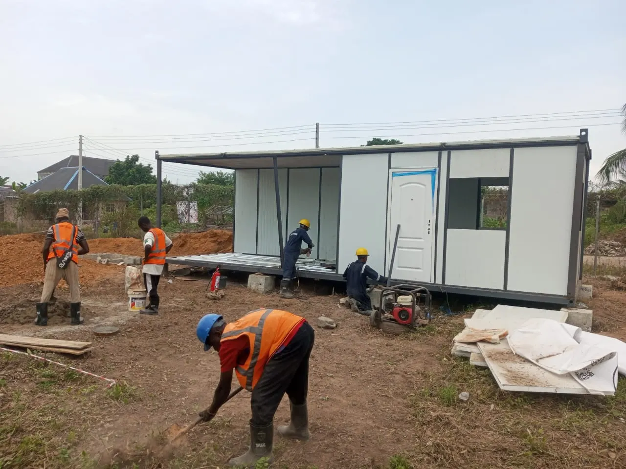 Crew installing a modular cabin on a construction site