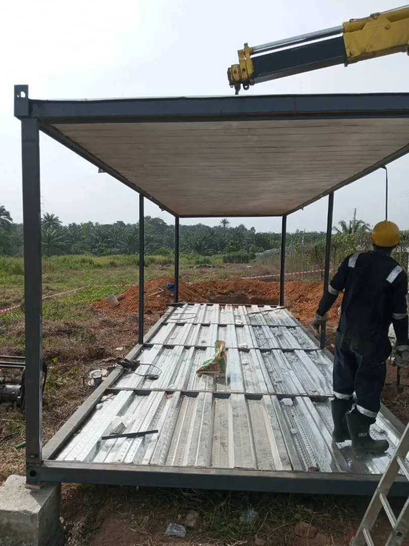 Crane lifting a steel module frame into position on site