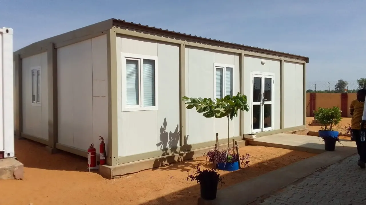 Completed single-storey porta cabin office with windows, door and air-conditioning units on a landscaped site