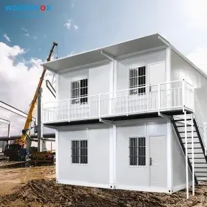 Two-storey modular building with external staircase being installed by crane